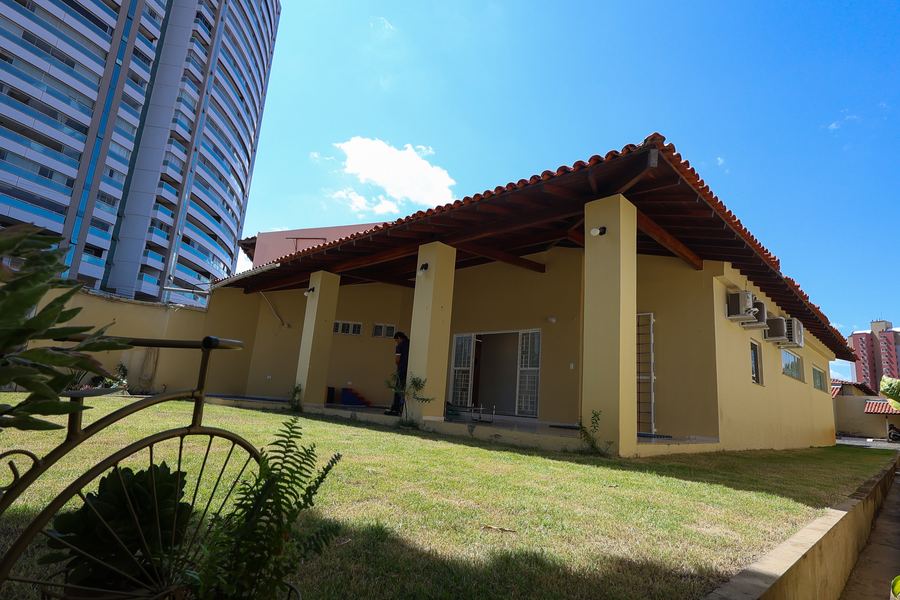 Área externa gramada do Instituto NeuroKids com varanda coberta