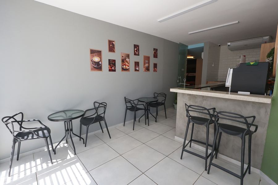 Casa Café com mesas, banquetas e balcão de cafeteria