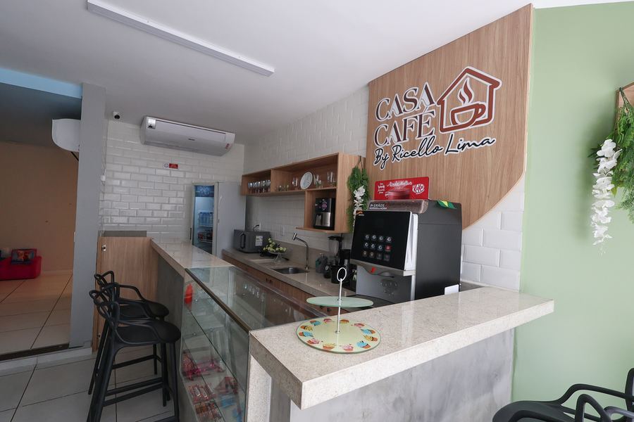 Balcão da Casa Café com máquina de café, vitrine e letreiro