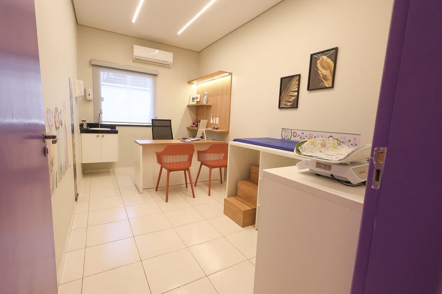 Consultório clínico do Instituto NeuroKids com bancada, cadeiras e maca infantil