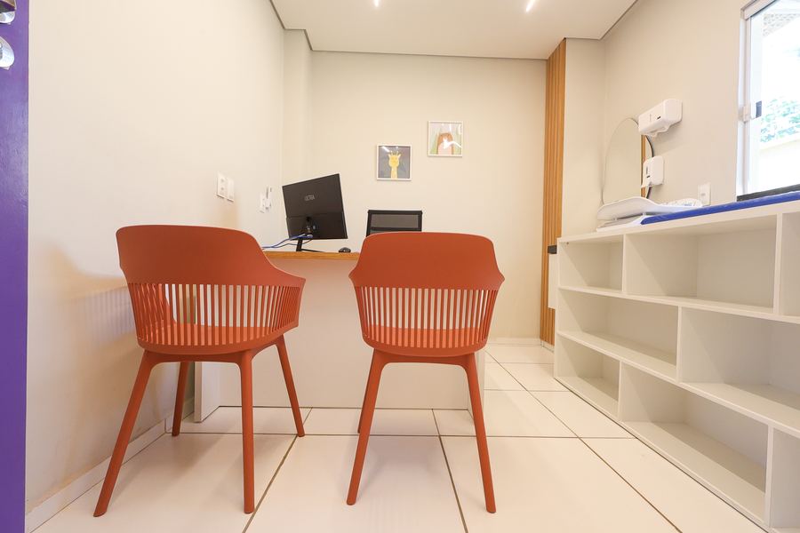 Consultório 04 com nichos abertos, cadeiras e porta roxa