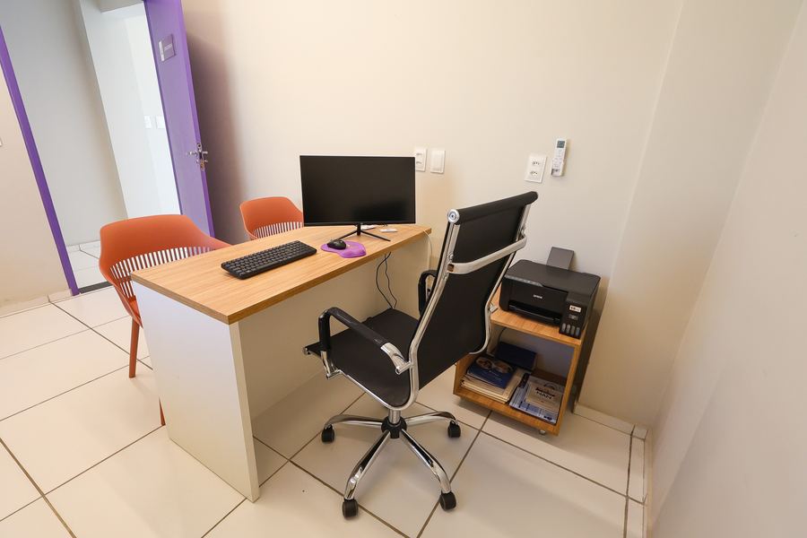 Consultório 04 com mesa de atendimento, cadeira executiva e impressora