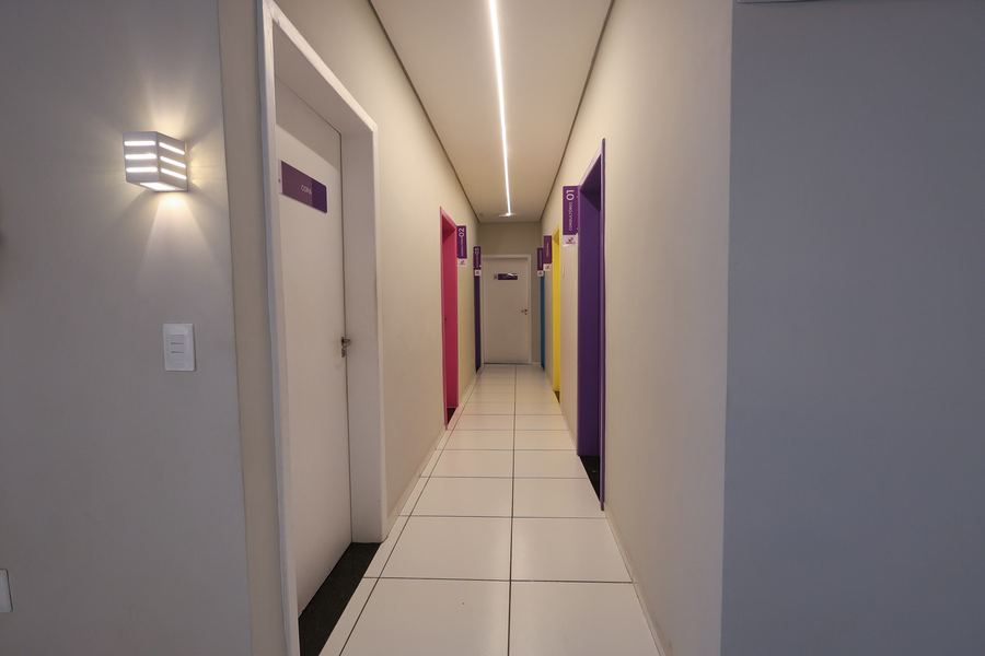 Corredor dos consultórios com portas coloridas e placas de identificação