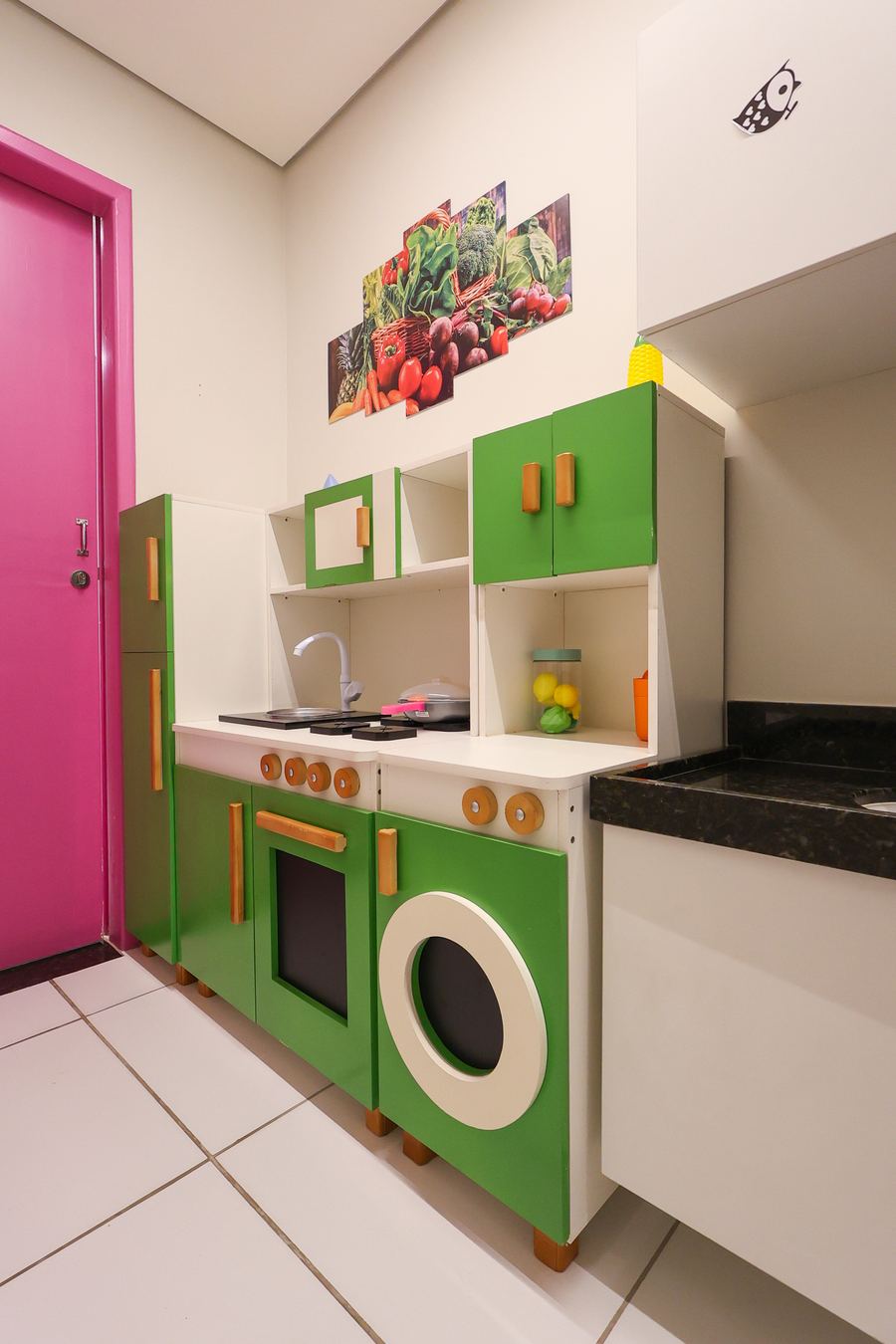 Cozinha Terapêutica com porta rosa, cozinha lúdica verde e bancada real