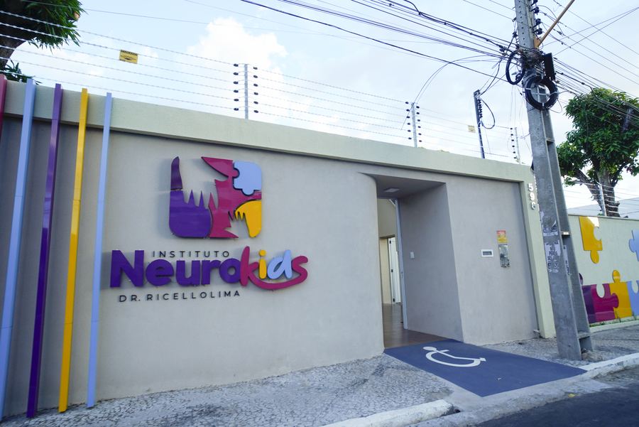 Fachada do Instituto NeuroKids vista da esquina, com mural de peças de quebra-cabeça