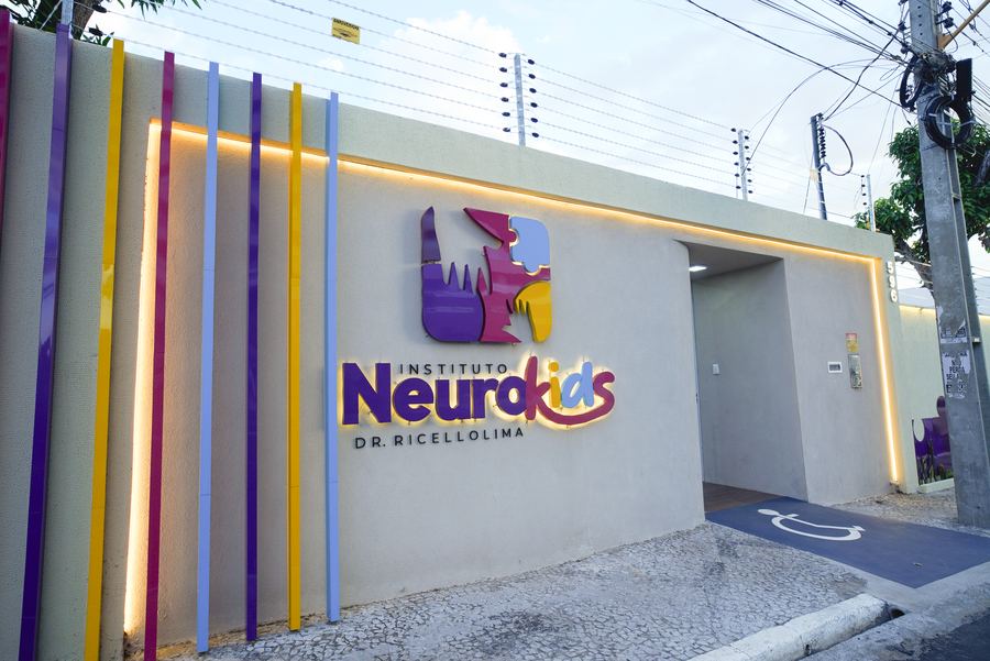 Fachada do Instituto NeuroKids com painéis coloridos verticais e logotipo