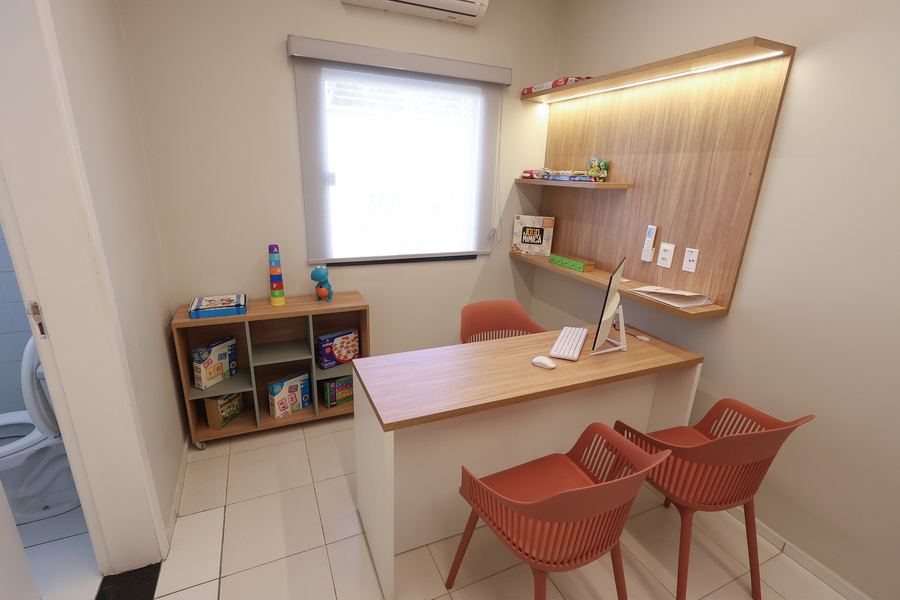 Sala de Fonoaudiologia com bancada de atendimento e estante de brinquedos