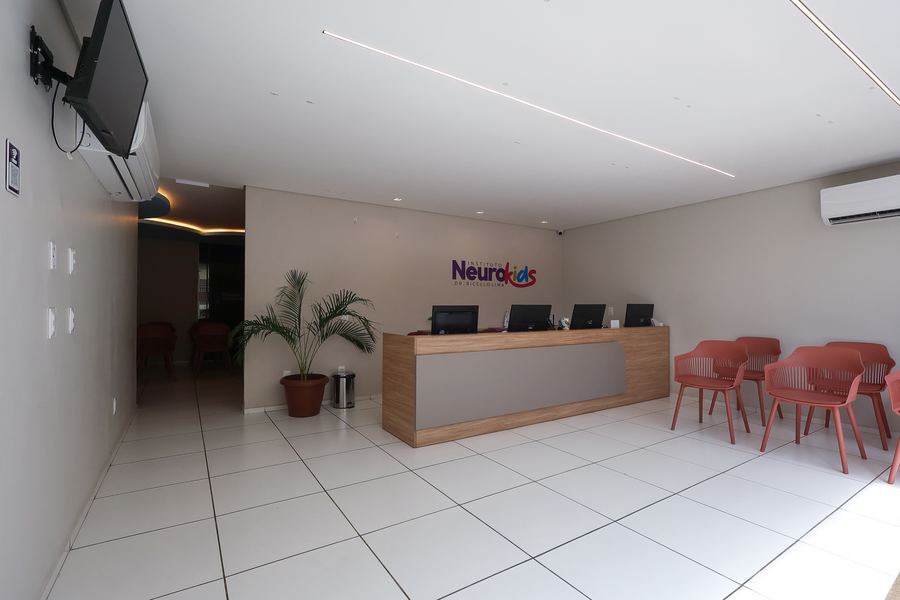 Recepção principal do Instituto NeuroKids com balcão de madeira e poltronas
