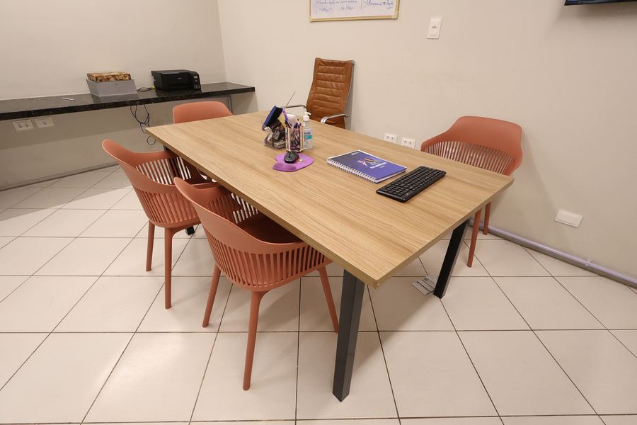 Sala de reunião com mesa ampla de madeira e cadeiras