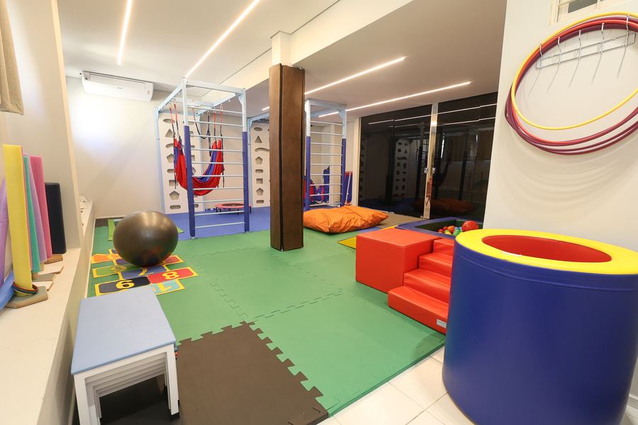 Sala de Terapia Ocupacional com piscina de bolinhas, rampa e arcos coloridos